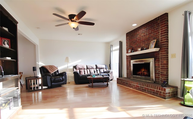 301 S Division St, Sapulpa, OK 74066 - living room featuring wood finished floors, a ceiling fan, a brick fireplace, and recessed lighting