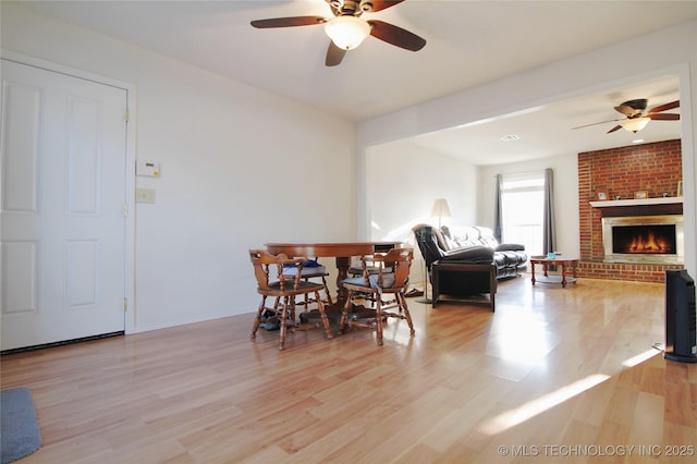 301 S Division St, Sapulpa, OK 74066 - dining space featuring ceiling fan, light wood-style floors, and a brick fireplace