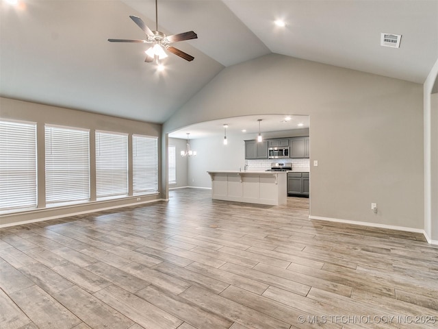 3604 E Quebec St, Broken Arrow, OK 74014 - unfurnished living room featuring ceiling fan, light wood-style flooring, a chandelier, and high vaulted ceiling