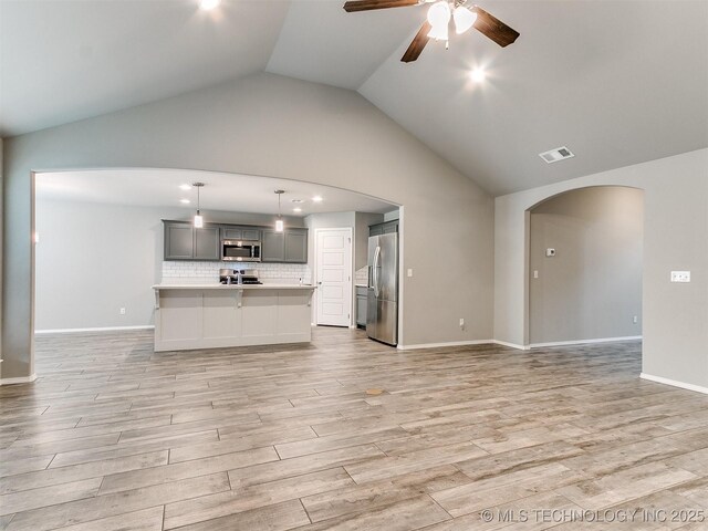 3604 E Quebec St, Broken Arrow, OK 74014 - kitchen with appliances with stainless steel finishes, open floor plan, arched walkways, light countertops, and a ceiling fan