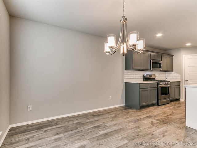 3604 E Quebec St, Broken Arrow, OK 74014 - kitchen featuring appliances with stainless steel finishes, gray cabinets, a chandelier, light wood-style flooring, and recessed lighting