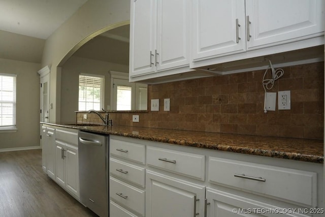 11906 S Nandina St, Jenks, OK 74037 - kitchen with stainless steel dishwasher, arched walkways, white cabinetry, wood finished floors, and dark stone countertops