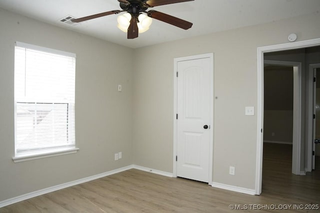 11906 S Nandina St, Jenks, OK 74037 - unfurnished bedroom with wood finished floors, multiple windows, and ceiling fan