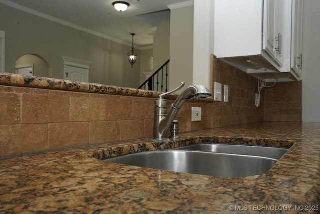 11906 S Nandina St, Jenks, OK 74037 - kitchen view of white cabinetry, decorative backsplash, ornamental molding, dark stone counters, and pendant lighting