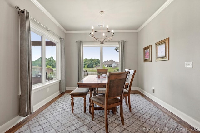 14305 S College Ave, Bixby, OK 74008 - dining room featuring wood finished floors, a chandelier, and ornamental molding