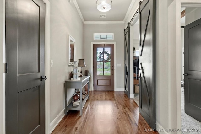 14305 S College Ave, Bixby, OK 74008 - entrance foyer with a barn door, wood finished floors, and crown molding