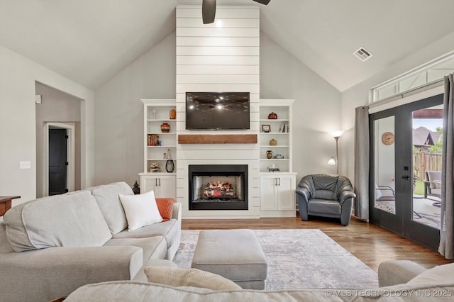 14305 S College Ave, Bixby, OK 74008 - living room featuring wood finished floors, high vaulted ceiling, french doors, a ceiling fan, and a fireplace