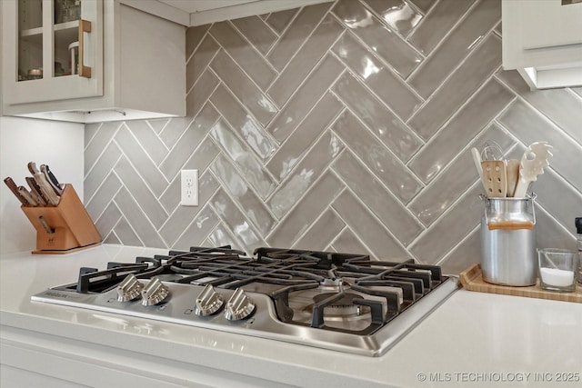 14305 S College Ave, Bixby, OK 74008 - kitchen view of stainless steel gas cooktop, tasteful backsplash, glass insert cabinets, and white cabinetry