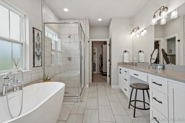 14305 S College Ave, Bixby, OK 74008 - full bathroom featuring a shower stall, a soaking tub, vanity, and recessed lighting