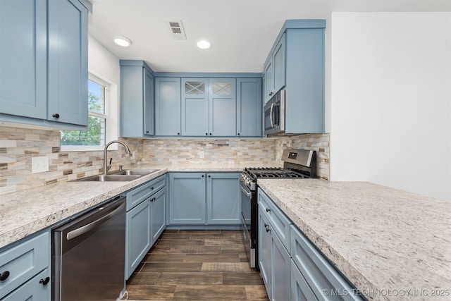 12317 E 18th St, Tulsa, OK 74128 - kitchen featuring stainless steel appliances, dark wood-style floors, light countertops, blue cabinetry, and recessed lighting