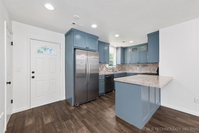 12317 E 18th St, Tulsa, OK 74128 - kitchen featuring stainless steel appliances, a peninsula, dark wood-type flooring, light countertops, and blue cabinets