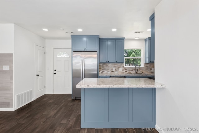 12317 E 18th St, Tulsa, OK 74128 - kitchen featuring freestanding refrigerator, a peninsula, blue cabinets, dark wood-style floors, and tasteful backsplash