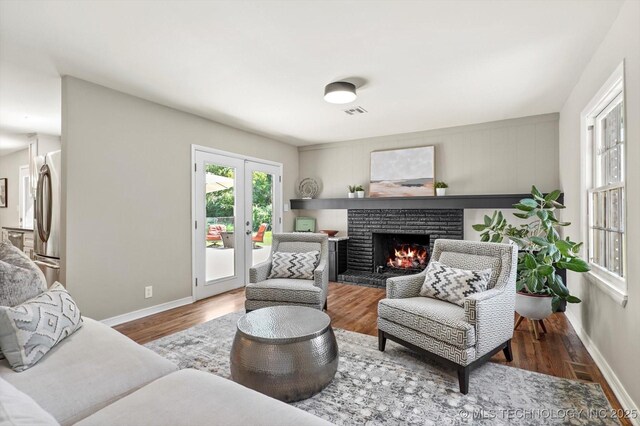 5861 S Hudson Pl, Tulsa, OK 74135 - living room featuring a warm lit fireplace, wood finished floors, and french doors