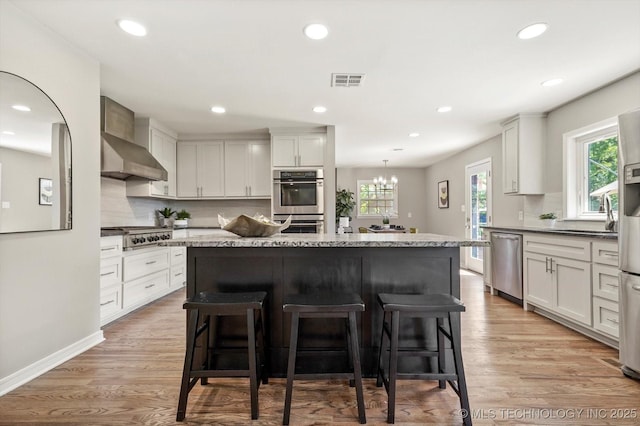 5861 S Hudson Pl, Tulsa, OK 74135 - kitchen featuring appliances with stainless steel finishes, a kitchen bar, plenty of natural light, and recessed lighting