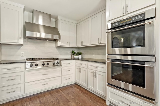 5861 S Hudson Pl, Tulsa, OK 74135 - kitchen with wall chimney range hood, appliances with stainless steel finishes, white cabinetry, and tasteful backsplash