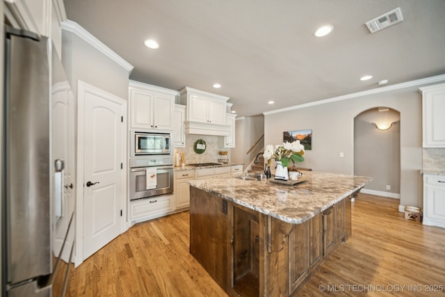 11802 S New Haven Ave, Tulsa, OK 74137 - kitchen with stainless steel appliances, arched walkways, crown molding, tasteful backsplash, and recessed lighting