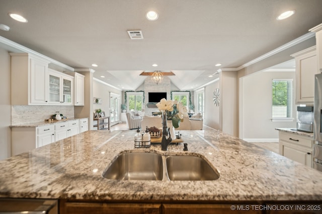 11802 S New Haven Ave, Tulsa, OK 74137 - kitchen with crown molding, light stone countertops, open floor plan, decorative backsplash, and healthy amount of natural light