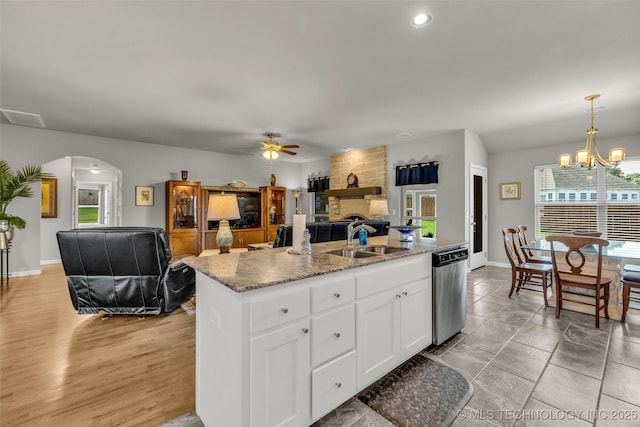 3331 Bunker St, Claremore, OK 74019 - kitchen featuring dishwasher, arched walkways, open floor plan, ceiling fan, and white cabinetry