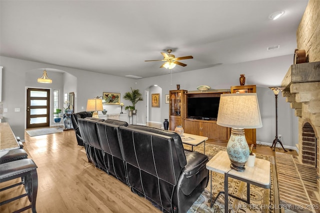 3331 Bunker St, Claremore, OK 74019 - living area featuring arched walkways, light wood finished floors, and a ceiling fan