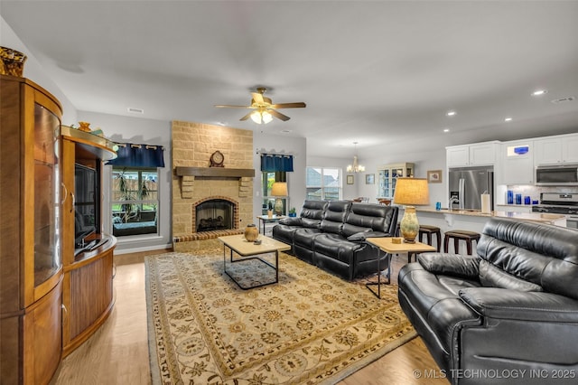 3331 Bunker St, Claremore, OK 74019 - living room featuring ceiling fan, recessed lighting, a chandelier, light wood-style flooring, and a fireplace