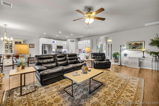 3331 Bunker St, Claremore, OK 74019 - living area with arched walkways, a ceiling fan, light wood finished floors, recessed lighting, and a chandelier