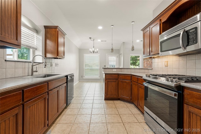 9005 N 154th E Ct, Owasso, OK 74055 - kitchen featuring stainless steel appliances, a chandelier, tasteful backsplash, a peninsula, and recessed lighting