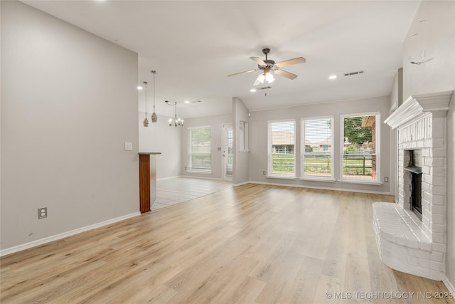 9005 N 154th E Ct, Owasso, OK 74055 - unfurnished living room featuring a ceiling fan, light wood-style floors, a chandelier, recessed lighting, and a fireplace