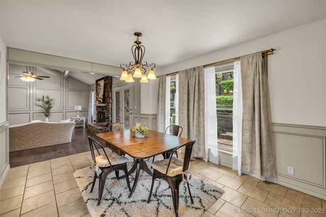 4350 E 74th Pl, Tulsa, OK 74136 - dining space featuring a decorative wall, vaulted ceiling, tile patterned flooring, a fireplace, and a chandelier