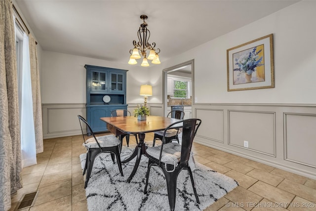 4350 E 74th Pl, Tulsa, OK 74136 - dining room with a decorative wall, a chandelier, light tile patterned floors, and a wainscoted wall
