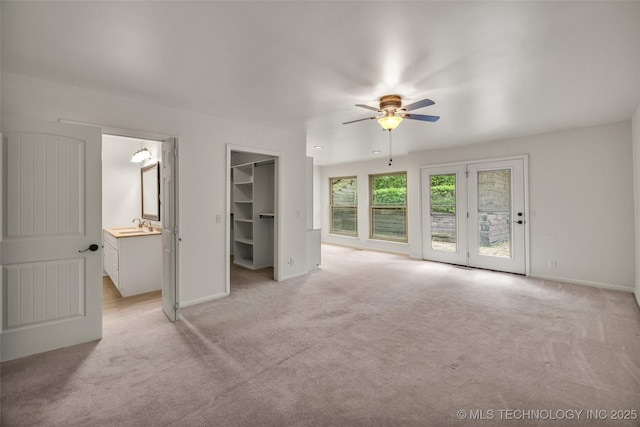 4350 E 74th Pl, Tulsa, OK 74136 - unfurnished bedroom featuring light colored carpet, access to exterior, a spacious closet, and ceiling fan