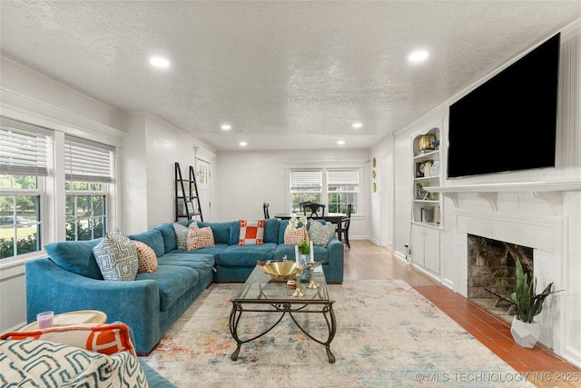 1640 E 41st St, Tulsa, OK 74105 - living area featuring a textured ceiling, recessed lighting, a brick fireplace, built in shelves, and ornamental molding