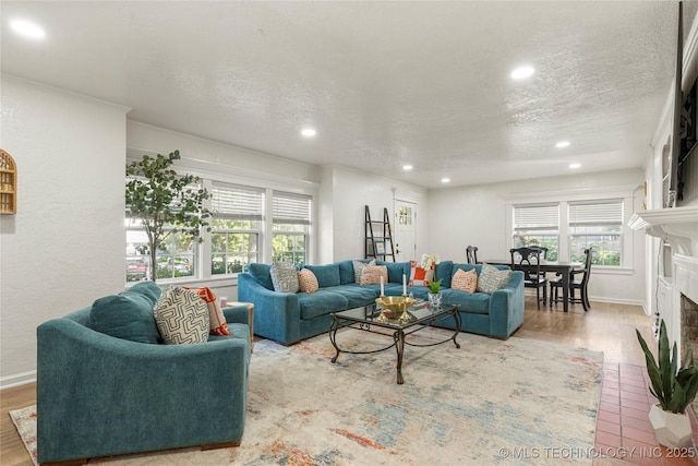 1640 E 41st St, Tulsa, OK 74105 - living room with recessed lighting, healthy amount of natural light, a fireplace with flush hearth, a textured ceiling, and wood finished floors