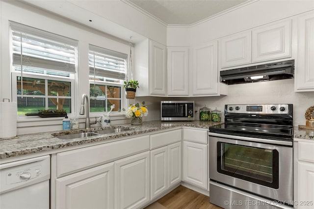 1640 E 41st St, Tulsa, OK 74105 - kitchen with stainless steel appliances, under cabinet range hood, white cabinets, light stone counters, and ornamental molding