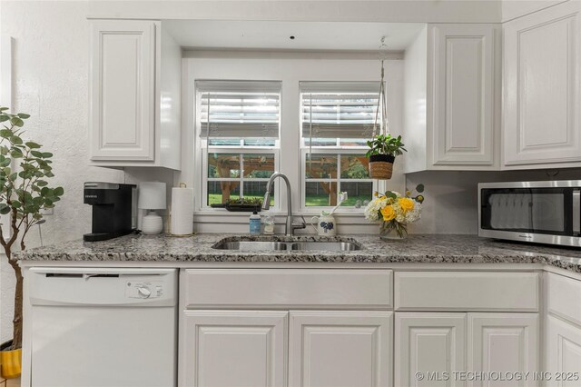 1640 E 41st St, Tulsa, OK 74105 - kitchen with stainless steel microwave, dishwasher, white cabinetry, and light stone countertops