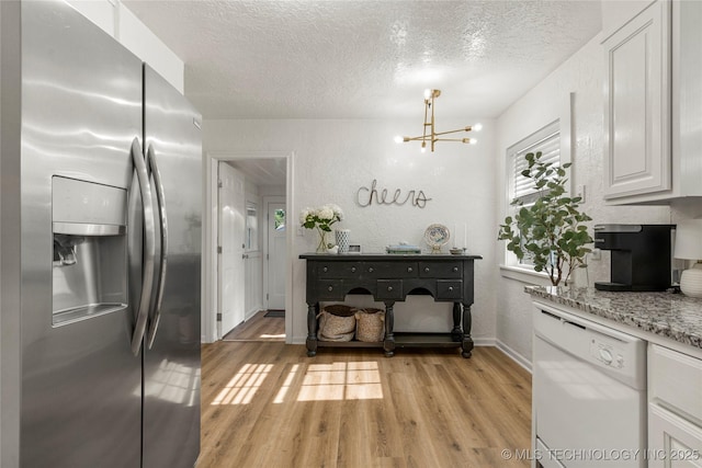 1640 E 41st St, Tulsa, OK 74105 - kitchen with stainless steel fridge, dishwasher, a chandelier, a textured ceiling, and light wood-type flooring