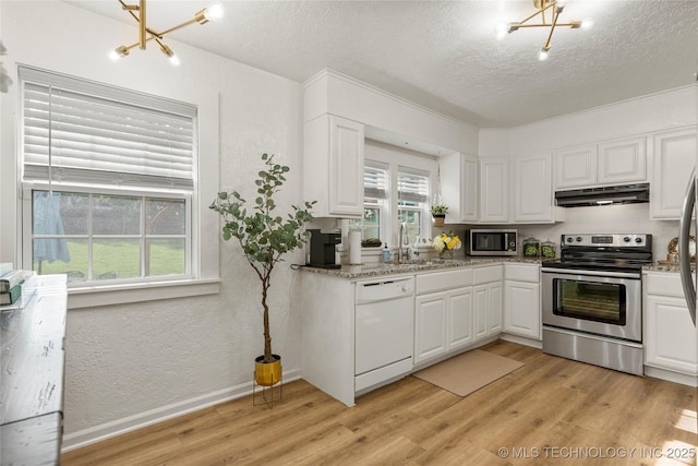1640 E 41st St, Tulsa, OK 74105 - kitchen with appliances with stainless steel finishes, a chandelier, under cabinet range hood, a textured ceiling, and light wood finished floors