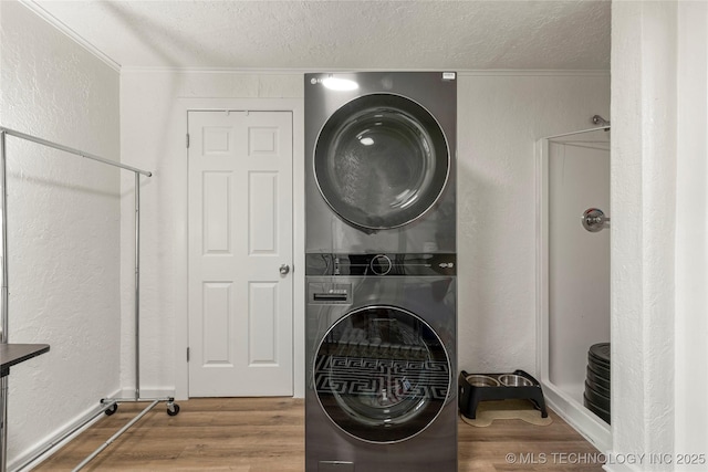 1640 E 41st St, Tulsa, OK 74105 - laundry area with stacked washer / drying machine, wood finished floors, a textured ceiling, ornamental molding, and a textured wall