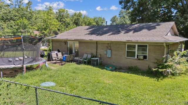 12131 E 32nd Pl, Tulsa, OK 74146 - back of property featuring brick siding, a trampoline, and roof with shingles