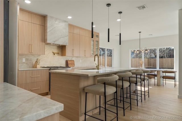1732 S Jamestown Ave, Tulsa, OK 74112 - kitchen featuring light brown cabinetry, modern cabinets, stainless steel range with gas cooktop, a breakfast bar, and recessed lighting