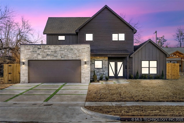 1732 S Jamestown Ave, Tulsa, OK 74112 - view of front of property with driveway, board and batten siding, an attached garage, stone siding, and roof with shingles