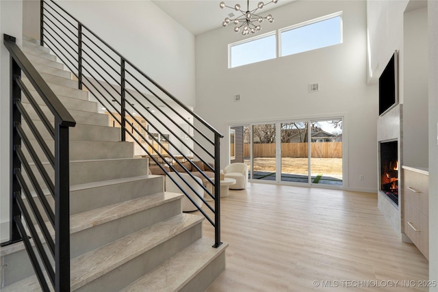1732 S Jamestown Ave, Tulsa, OK 74112 - stairs with a high ceiling, a chandelier, wood finished floors, and a high end fireplace