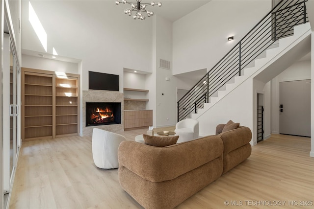 1732 S Jamestown Ave, Tulsa, OK 74112 - living room with wood finished floors, stairway, a tile fireplace, a high ceiling, and a chandelier