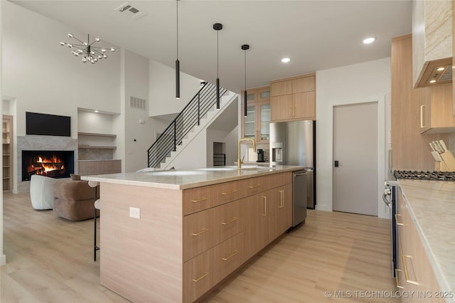 1732 S Jamestown Ave, Tulsa, OK 74112 - kitchen with light brown cabinetry, light wood-type flooring, appliances with stainless steel finishes, wall chimney range hood, and recessed lighting