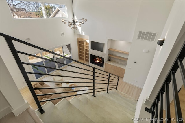 1732 S Jamestown Ave, Tulsa, OK 74112 - stairs with wood finished floors, a warm lit fireplace, and a high ceiling