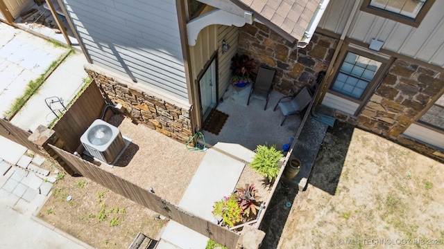 6376 S 80th E Ave Unit G, Tulsa, OK 74133 - view of side of property featuring stone siding and roof with shingles
