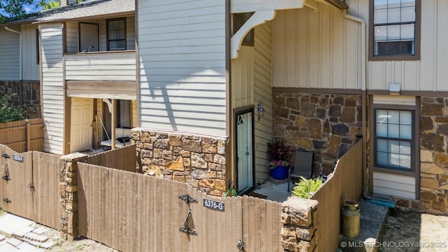 6376 S 80th E Ave Unit G, Tulsa, OK 74133 - view of side of home featuring stone siding and board and batten siding