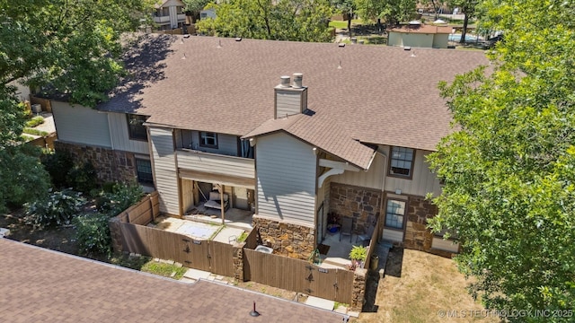6376 S 80th E Ave Unit G, Tulsa, OK 74133 - view of front facade featuring stone siding, a gate, roof with shingles, and a chimney