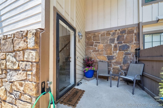6376 S 80th E Ave Unit G, Tulsa, OK 74133 - doorway to property featuring stone siding and a patio area