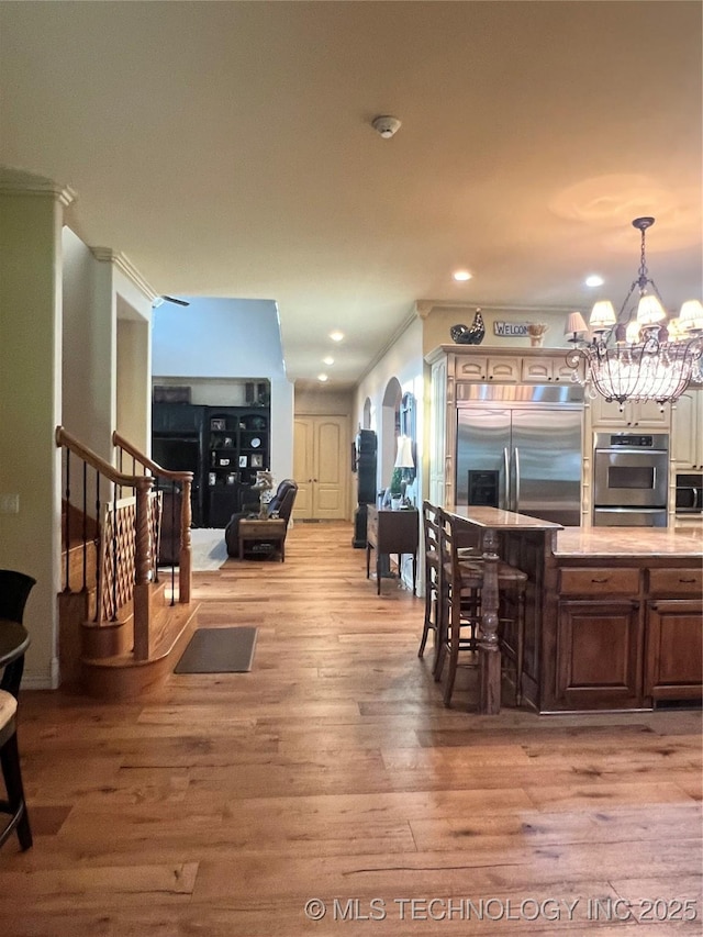 910 Summit Rdg, Mcalester, OK 74501 - dining space featuring light wood finished floors, a chandelier, recessed lighting, stairs, and arched walkways