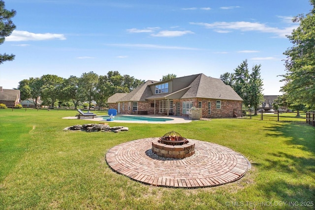 7185 N 194th E Ave, Owasso, OK 74055 - back of property with a fire pit, an outdoor pool, a lawn, and brick siding